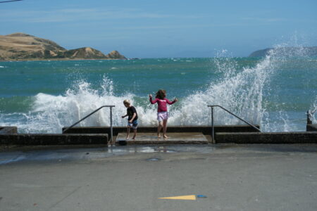 Kids enjoy wave dancing at high tide